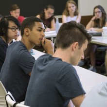 A close-up of a row of students sitting in a u-shape in a small discussion-based course.